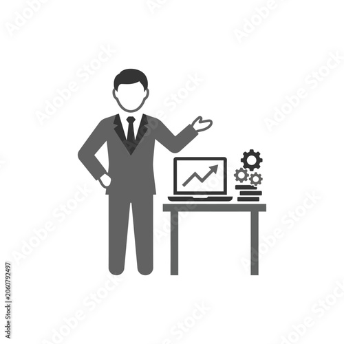 Businessman standing by desk with laptop displaying growth graph.