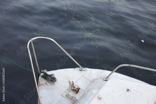 White boat floats on calm, dark water
