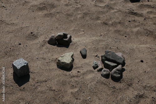 Fotografie Dusty ground holds scattered rocks of varying shapes and sizes