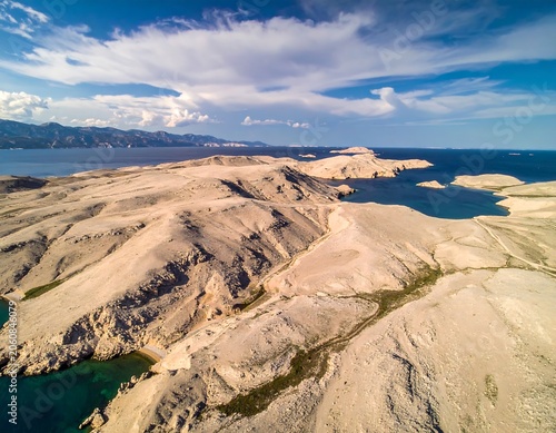 Vast arid landscape with canyons and blue water under cloudy sky