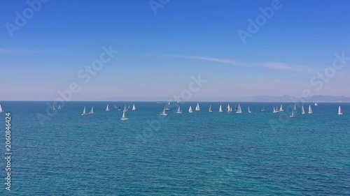 Drone flies over group of sailing yachts on Mediterranean sea – sunny regatta with blue horizon