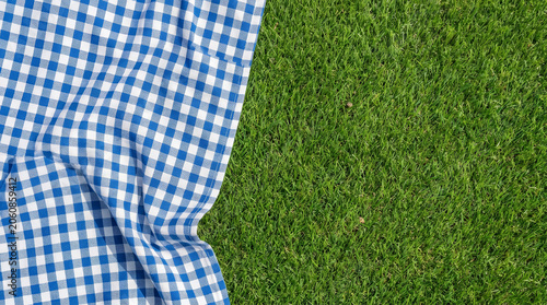 Picnic blanket layout grass outdoor leisure summer fabric blue white checkered pattern background. summer leisure park. background fabric display, material textile nature, simple design surface