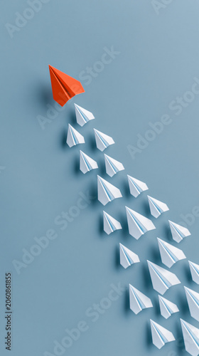 Leadership Takes Flight: An orange paper airplane leads a fleet of white paper airplanes in a dynamic formation, symbolizing innovation and forward momentum.