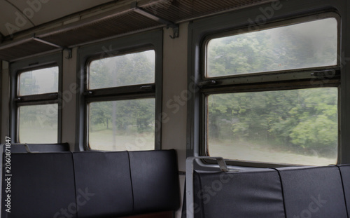 Empty train carriage with dark seats and large windows