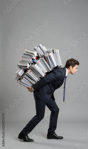 Businessman carrying a mountain of passwords on his back, cybersecurity concept