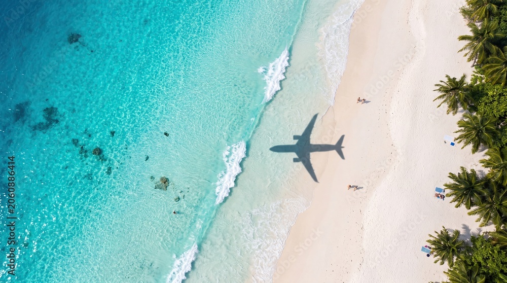 Obraz premium Tropical beach travel concept with airplane shadow over turquoise sea