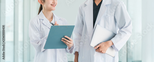 Photos Male and female researchers, scientists, and research staff (pharmaceutical company, research institute) in white coats conversing and consulting with colleagues