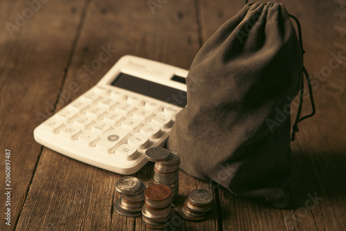 Cuadro en lienzo Calculator and coins on wooden table, business and finance concept