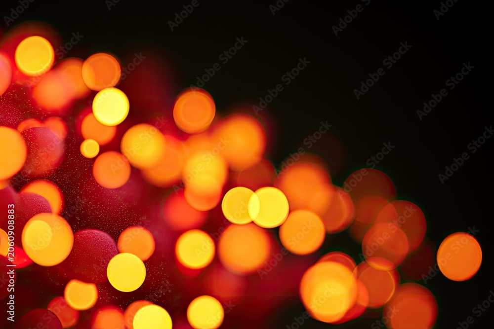 Fototapeta premium Blurry warm-toned lights, red and yellow bokeh circles, dark background