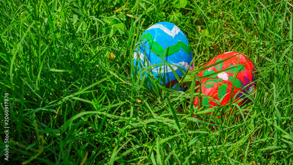 Fototapeta premium Colorful Painted Easter Eggs Hidden in Lush Green Grass