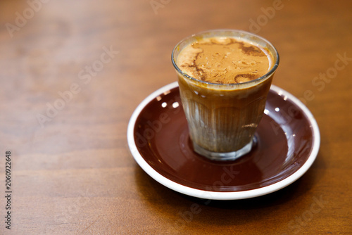 Glass of milk latte coffee on a wooden table.