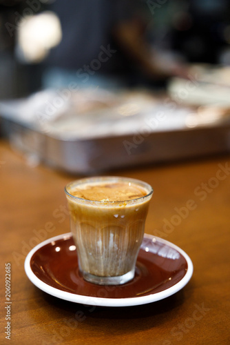 Glass of milk latte coffee on a wooden table.