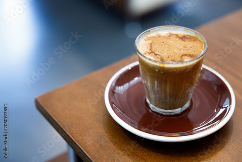 Glass of milk latte coffee on a wooden table.