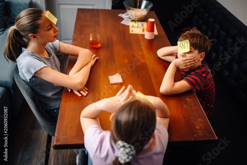 Картината върху платно Children playing guessing game with sticky notes
