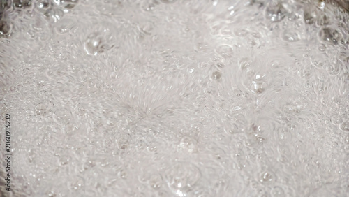 Tableau sur toile Close-up view of vigorously boiling water with countless small bubbles creating
