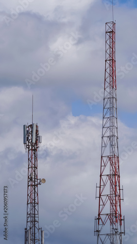 High Steel Telecommunication Towers Standing Against a Partly Cloudy Blue Sky Background for Modern Data Connectivity