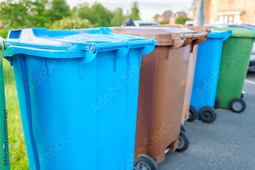 Residential recycling and waste bins lined up for collection in suburban neighborhood