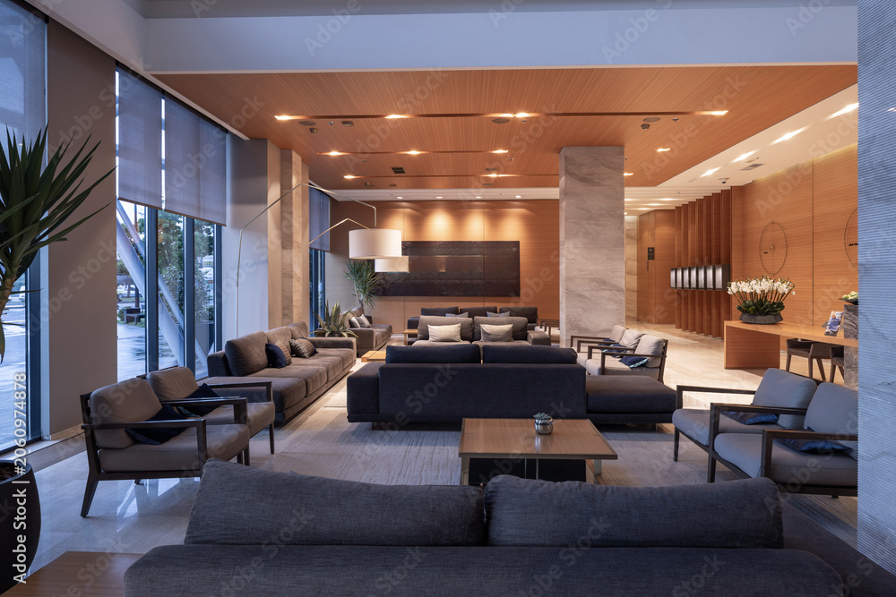 Naklejka premium Luxury hotel lobby lounge area with stylish sofas and wooden ceiling