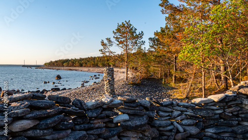Canvastavla beautiful rocky seashore, colorful water and bright sky, white, smooth stones,
