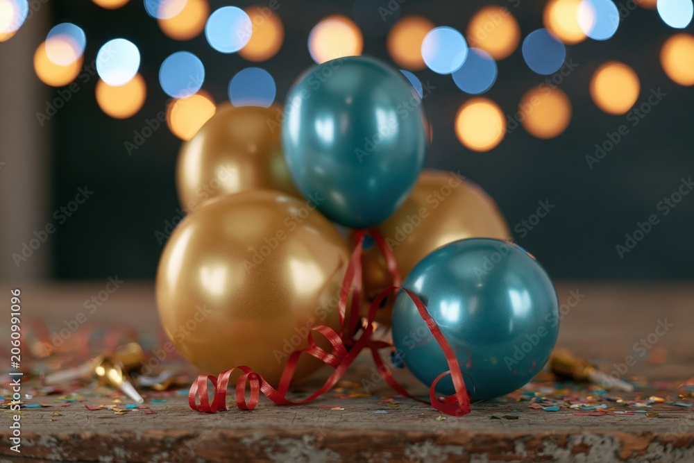 Obraz premium The Balloons Create Festive Glow on Rustic Table With Colorful Confetti
