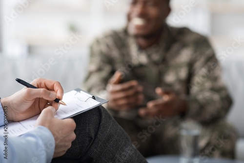 Foto Smiling Black Male Soldier Engaging In Friendly Conversation With Counselor, Seated In Office Setting