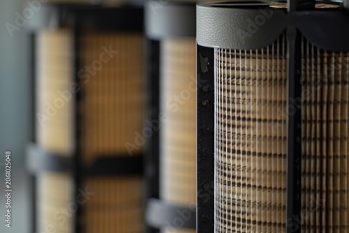 Closeup of cylindrical industrial filters showing filtering material, selective focus