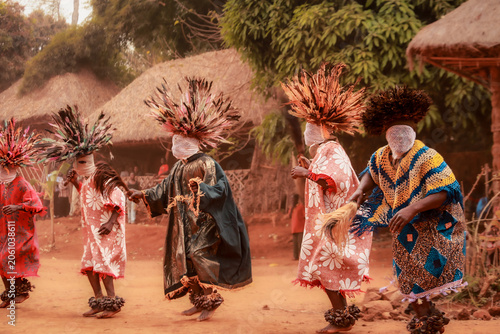 Fotografija Masked dancers, wearing woven face coverings, colorful robes, and elaborate feathered headdresses,  perform a traditional ceremonial dance in the Babungo Kingdom of Cameroon