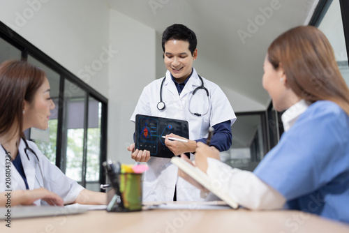 Cuadro en lienzo Professional Asian doctor presenting digital medical scans to colleagues during a team meeting, Healthcare and medical team concept