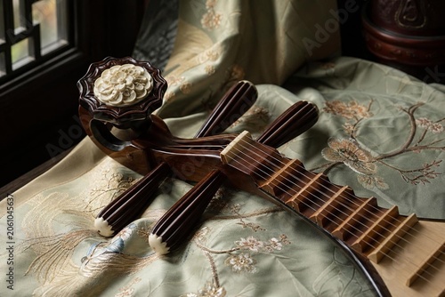 Exquisite pipa lute resting on embroidered silk fabric with curved headstock.