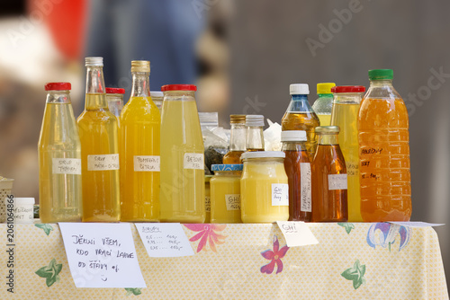 Photography Assortment of handmade bottled syrups, juices, and ghee on a table at the Hermanak farmers market in Prague Holesovice