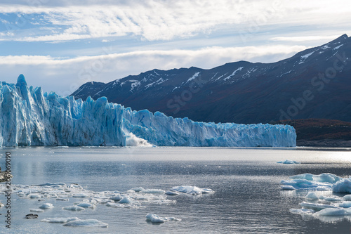 Perito moreno glacier patagonia los glaciares national park bright ice wall above lake with mountain and cloud