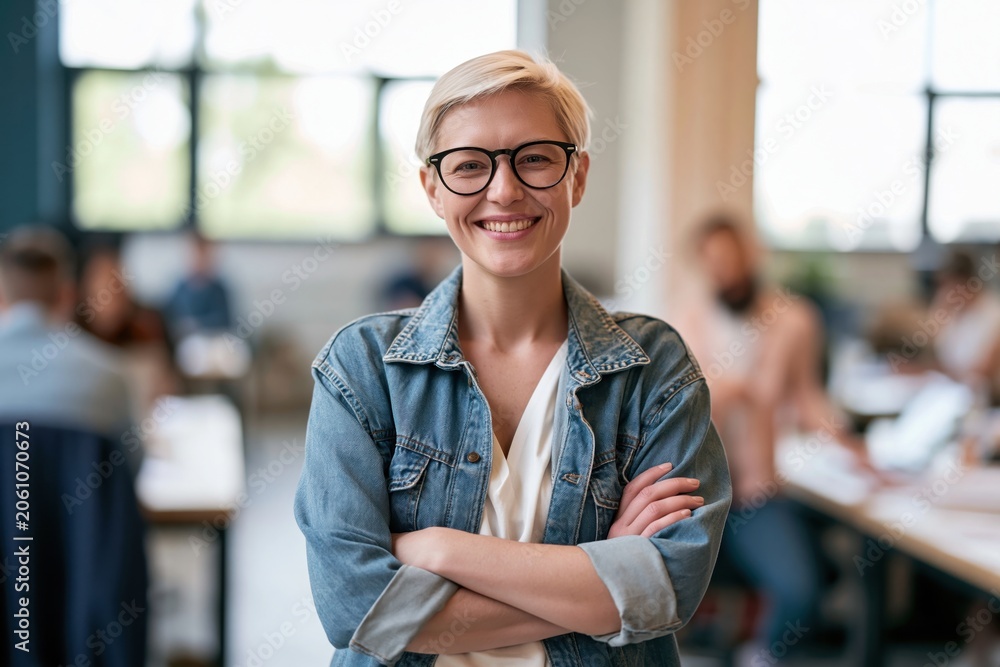 Fototapeta premium The Teacher in Denim Jacket Smiling in a Bright Classroom