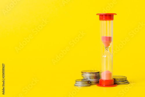 Deadline and time is money concept with hourglass and US coins currency. sand clock time for saving concept