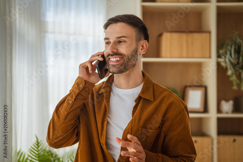 Young man talking on phone feeling happy