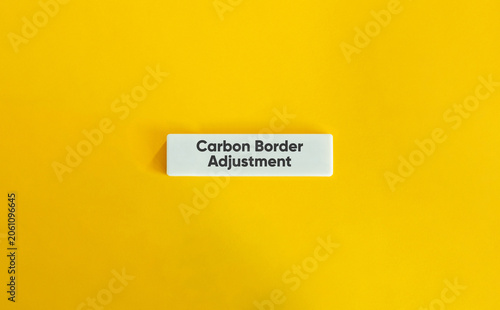 Carbon border adjustment environment policy text white block yellow background concept representing international trade tariff and corporate climate strategy