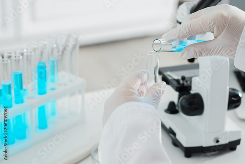 Scientist pouring blue liqu...