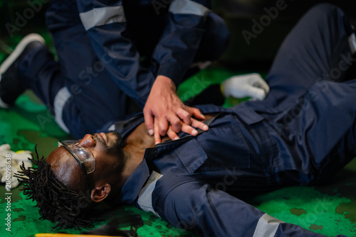 Fotografie Close-up of lifesaving CPR procedure performed by industrial employee following workplace accident