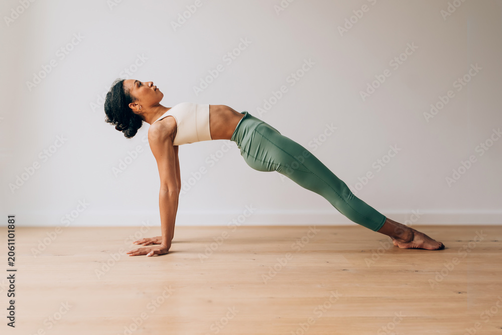 Naklejka premium Woman exercising reverse plank pose for wellness