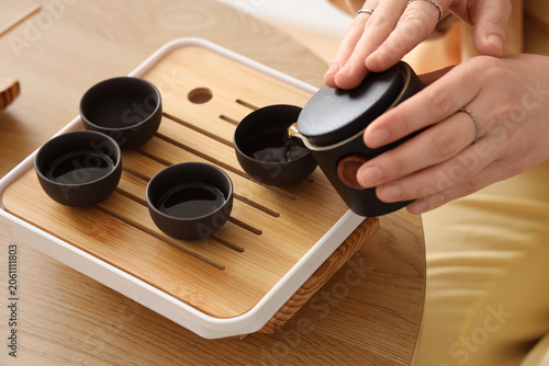 Young woman pouring tea fro...