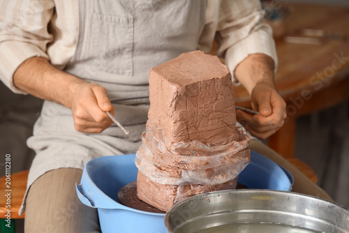 Potter using wire clay cutt...