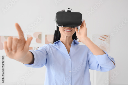 Young woman using VR glasses in modern art gallery