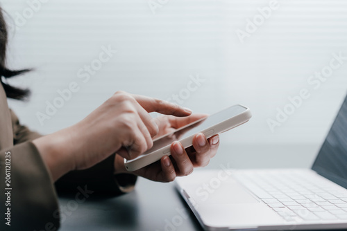 Obraz na plátně businesswoman touching a smartphone screen working with laptop