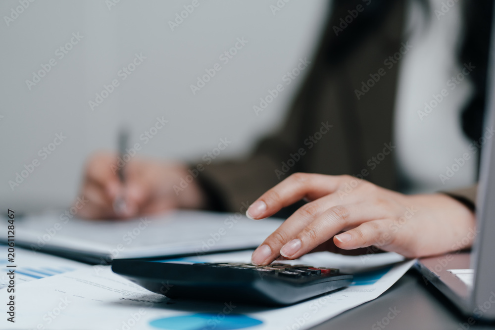 Fototapeta premium Business people hands working with a calculator and financial documents at an office desk, corporate accountant auditing data, planning budget or investment