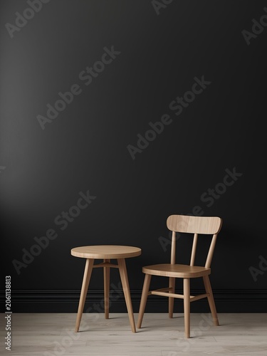 A minimalist interior mockup featuring a sleek matte black wall contrasted with a light oak wooden chair and round side table. The clean lines, natural wood textures, and dramatic dark background