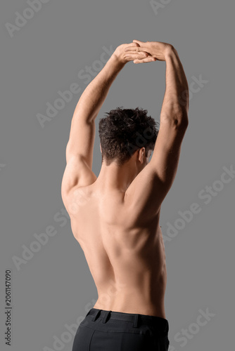 Muscular young man on grey ...