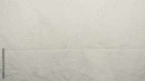 white linen fabric ripples gently in macro slow motion showcasing organic textile weave texture under bright soft light