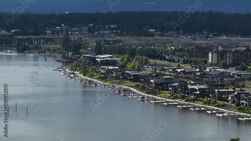 Aerial close up of urban waterfront in Coeur dAlene Idaho along Spokane River with dense forest backdrop