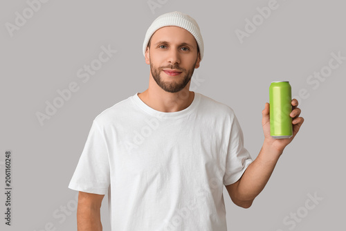 Young man with can of cold ...