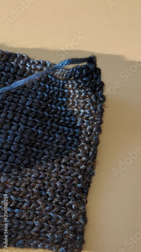 Textured blue knitted fabric, showcasing the intricate stitch pattern and soft fibers. Crafting crochet clothes textile