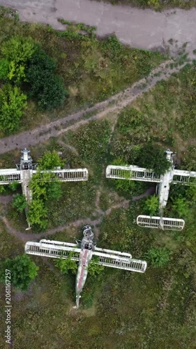 Aerial topdown on rustic An-2 Antonov airplanes abandoned in field, aviation remains in greenery